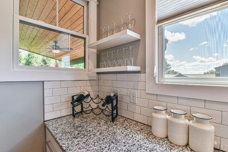 A kitchen with granite countertops, a wine rack, and a window.
