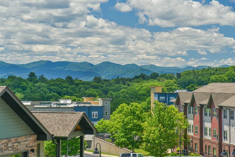 A view of a city with mountains in the background and a building in the foreground.