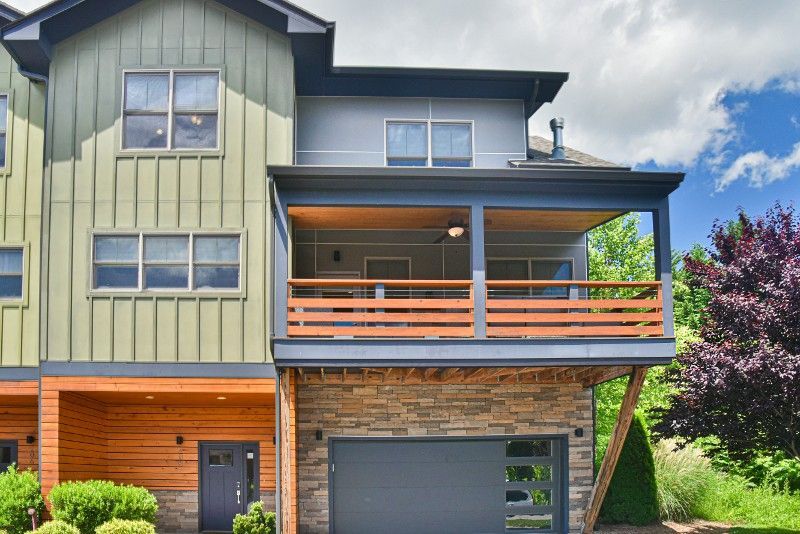 A large house with a large porch and a garage.