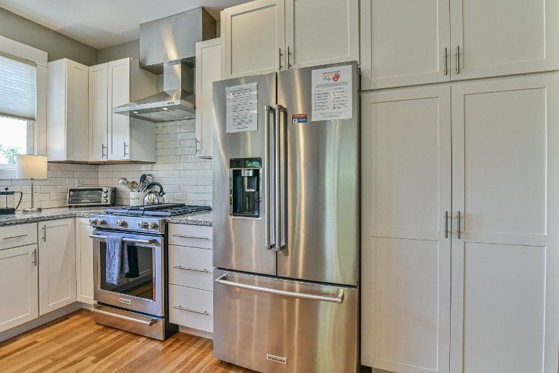 A kitchen with stainless steel appliances and white cabinets.