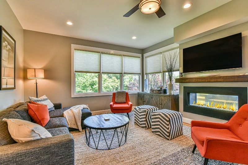 A living room with a fireplace, couch, chairs, coffee table, and television.