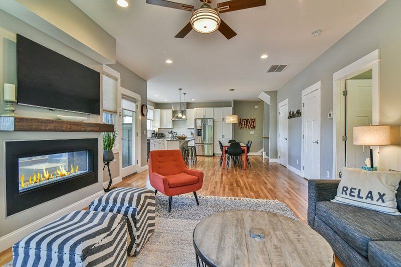 A living room with a fireplace, couch, chair, coffee table, and television.