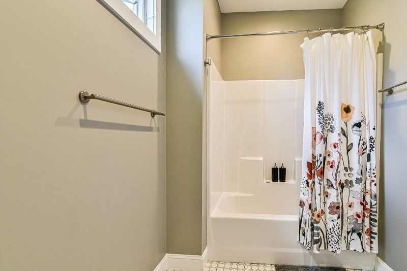A bathroom with a shower curtain and a bathtub.