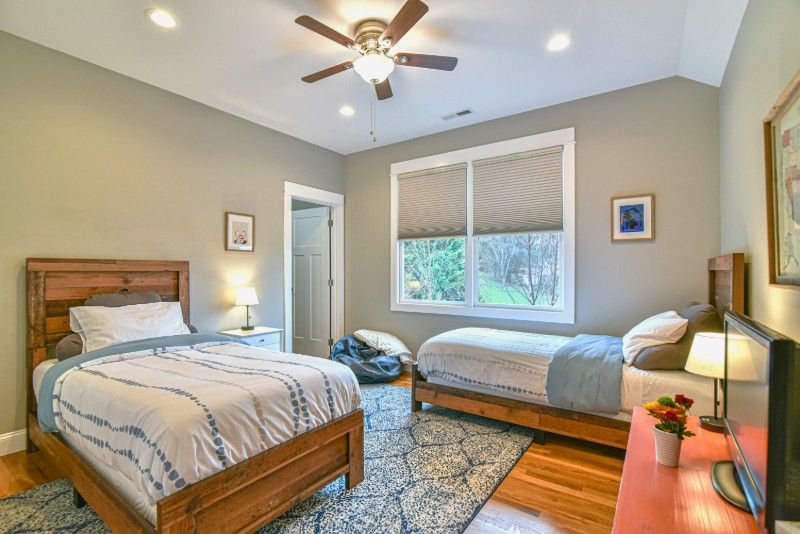 A bedroom with two beds and a ceiling fan.