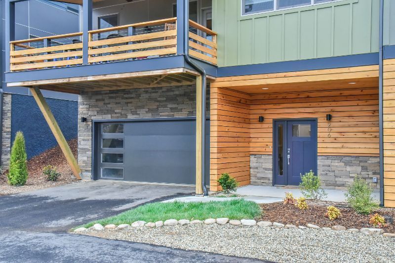 The front of a house with a garage and a balcony.