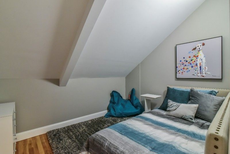 There is a picture of a dog on the wall above the bed.