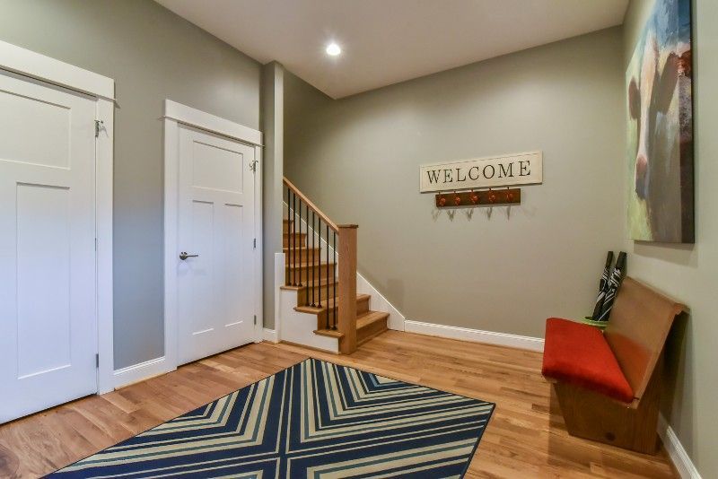 A hallway with stairs and a welcome sign on the wall.