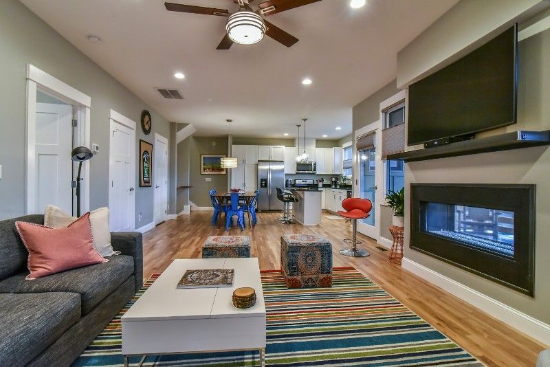A living room with a couch , coffee table , fireplace and television.
