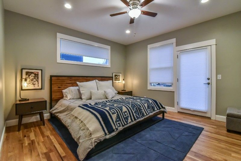 A bedroom with a large bed and a ceiling fan