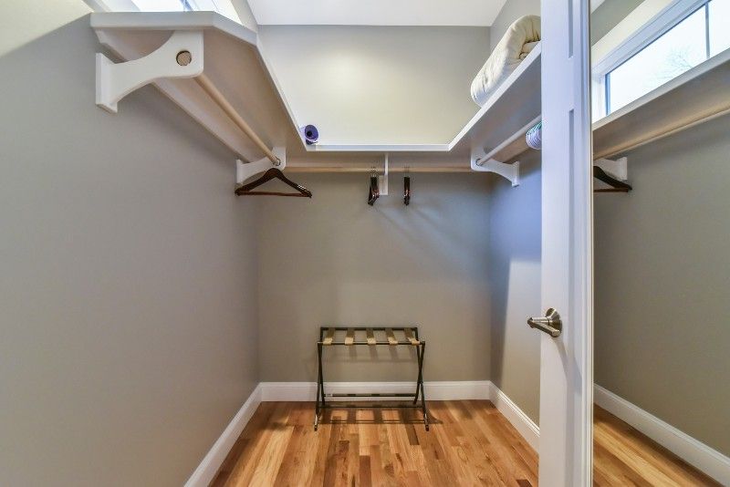 A walk in closet with a stool and a mirror