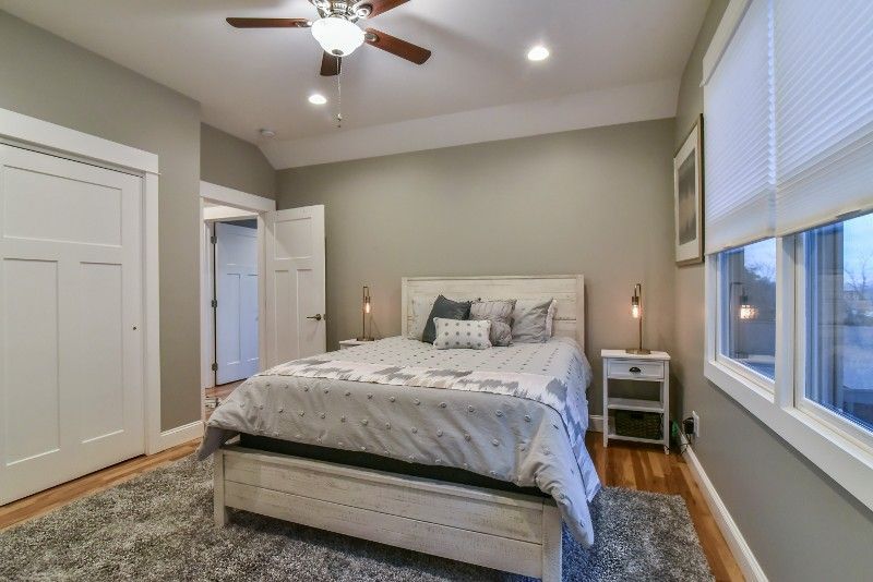 A bedroom with a large bed and a ceiling fan.