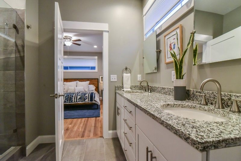 A bathroom with two sinks and a walk in shower.
