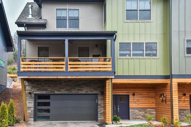 A modern house with a large garage and a porch.