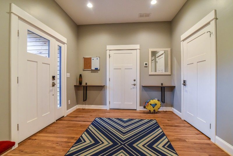 A hallway with a rug and a soccer ball on the floor.