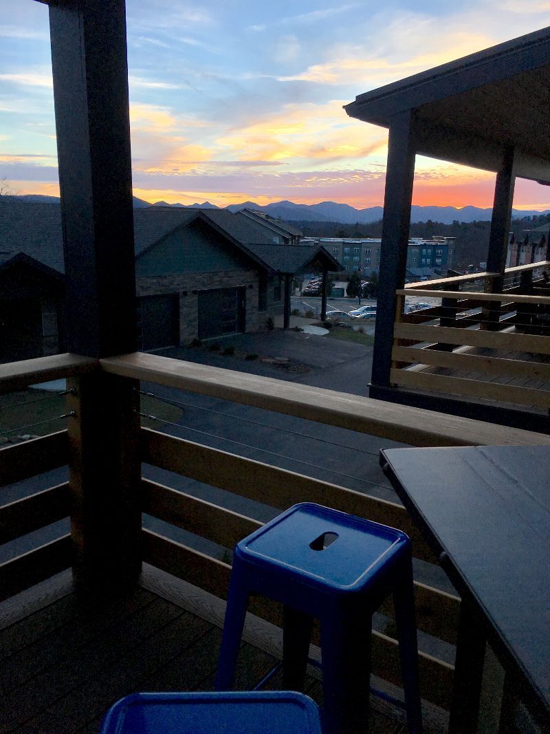 A balcony with a view of a city at sunset.