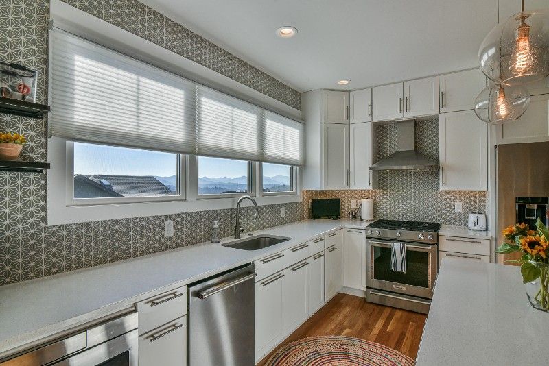 A kitchen with white cabinets and stainless steel appliances