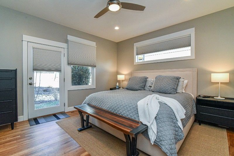 A bedroom with a king size bed and a ceiling fan.