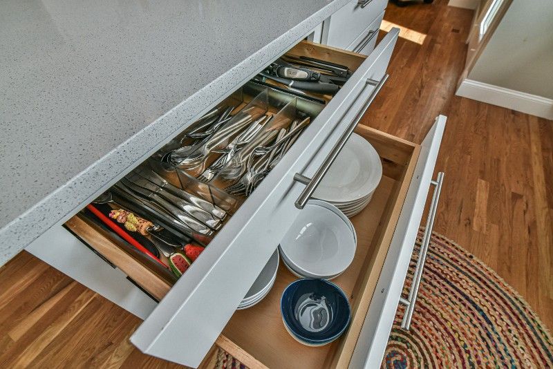 A kitchen drawer filled with utensils and bowls.