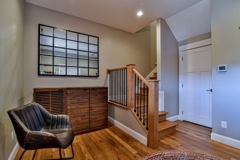 A living room with hardwood floors , a chair and stairs.