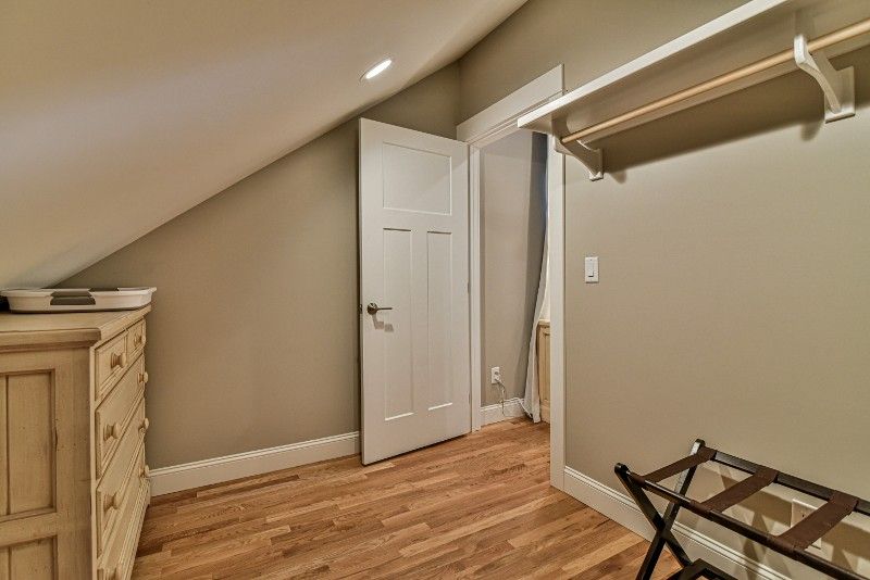 A walk in closet with a dresser and a suitcase rack.