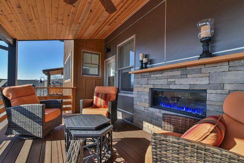 There is a fireplace on the porch of a house.