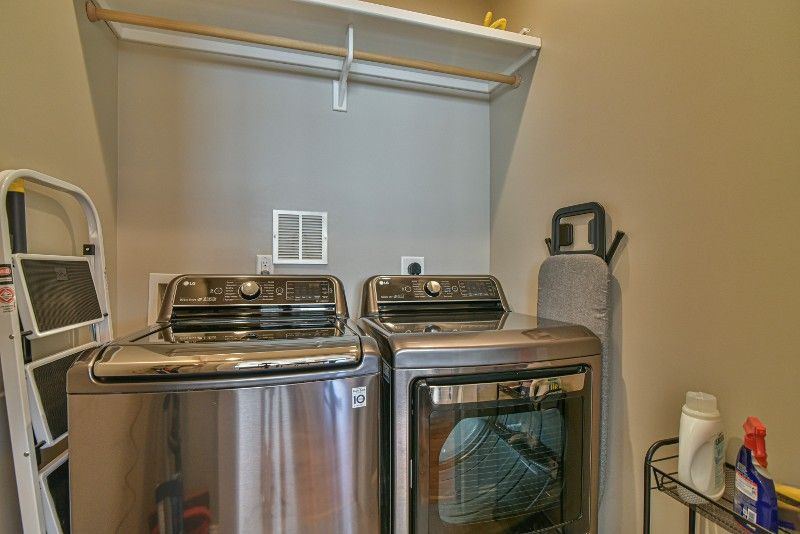 A laundry room with a washer and dryer and a ladder.