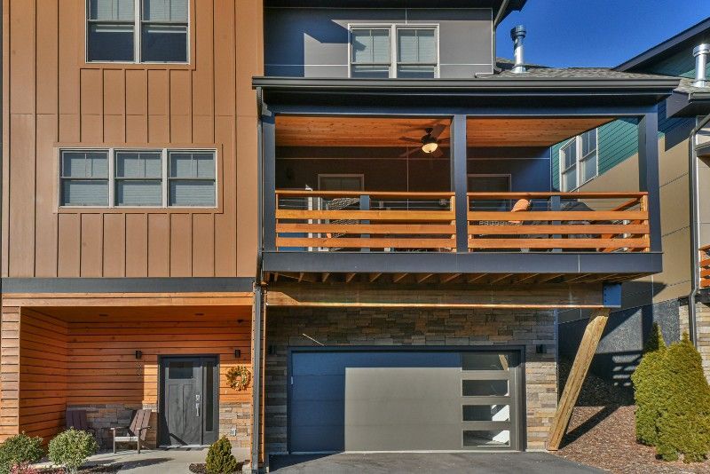 The front of a house with a large garage and a balcony.