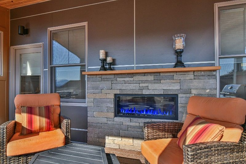 A patio with two chairs and a fireplace.