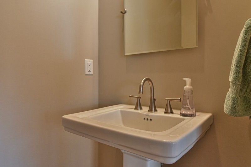A bathroom sink with a soap dispenser and a mirror.