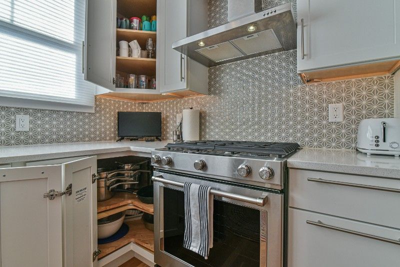 A kitchen with stainless steel appliances and white cabinets.
