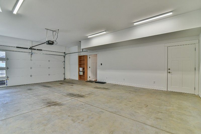 A large empty garage with a garage door open.