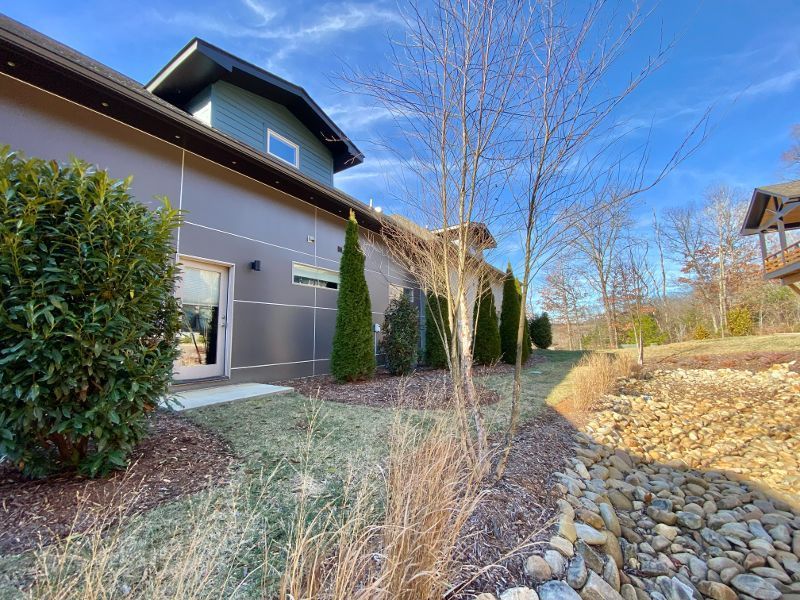 A large house with a lot of trees and bushes in front of it.