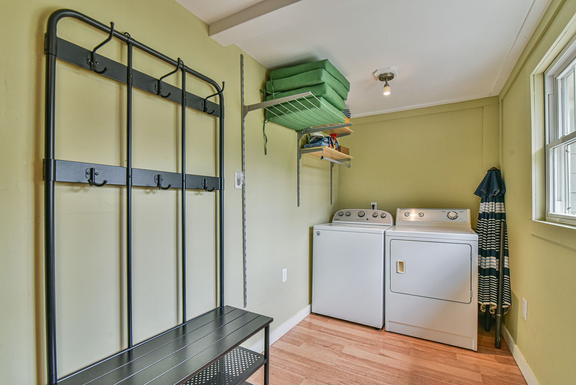 Laundry room with washer, dryer, hanging racks, and storage shelves