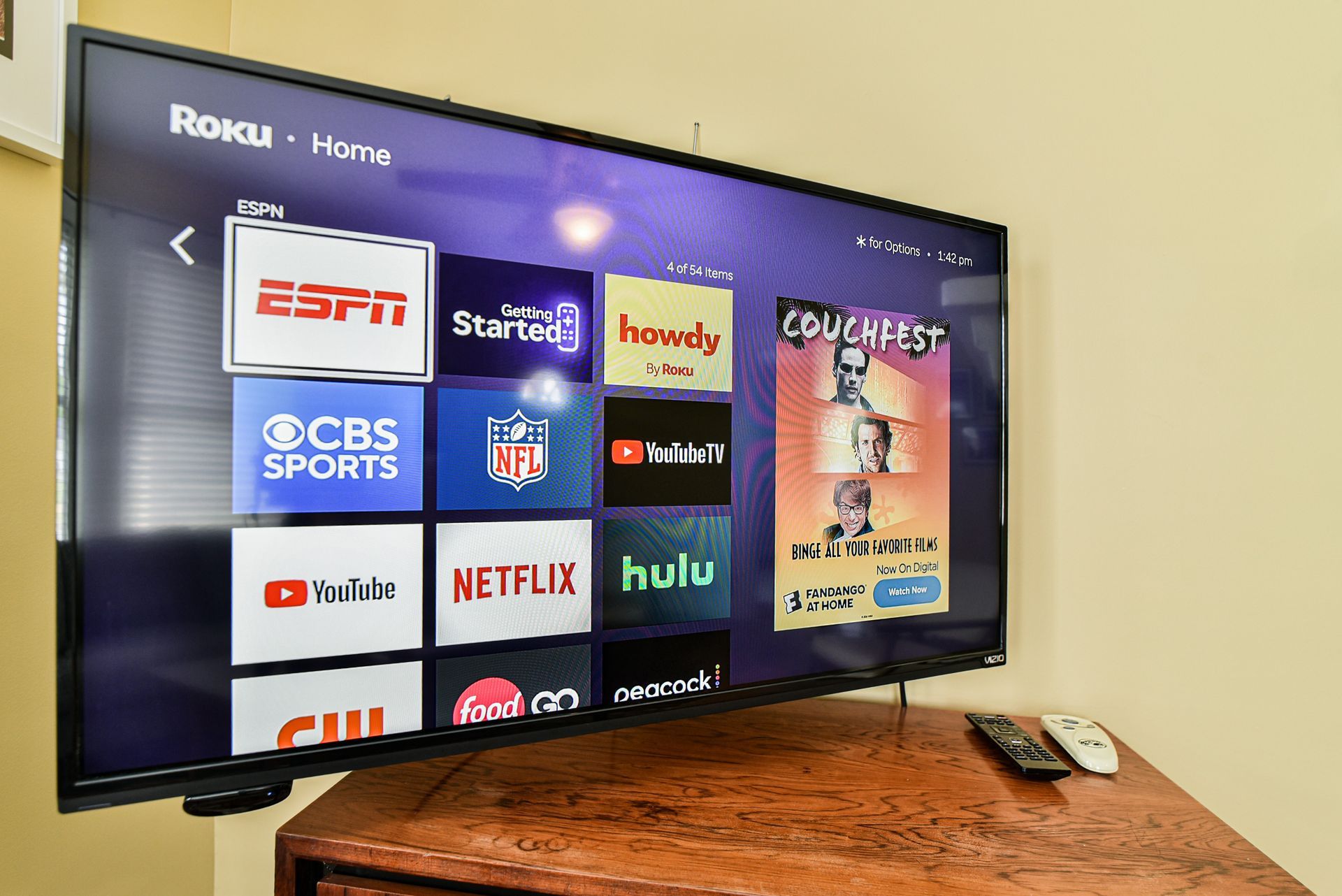 Roku home screen on a TV with streaming app tiles in a living room