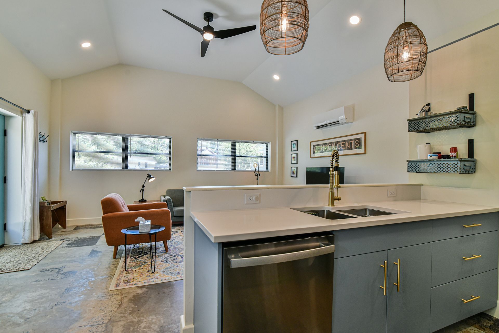 Bright modern kitchen and dining area with island, pendant lights, and large windows