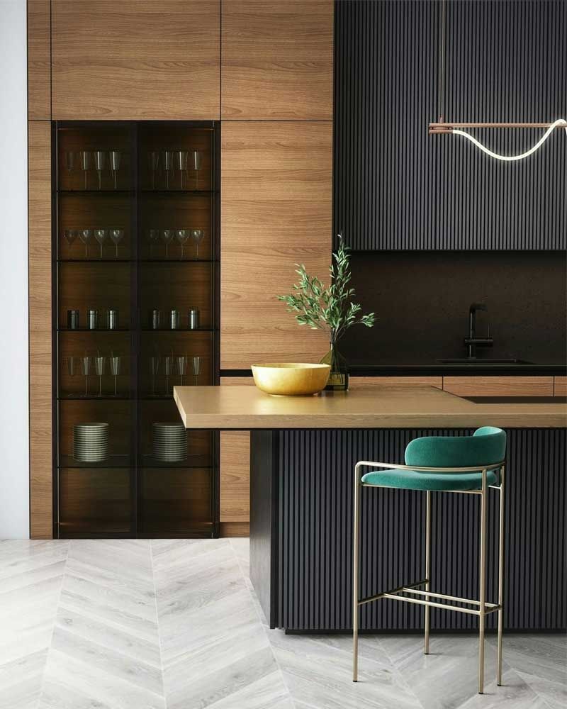Modern kitchen with wood cabinetry, black slatted island, teal barstool, and warm pendant lighting.