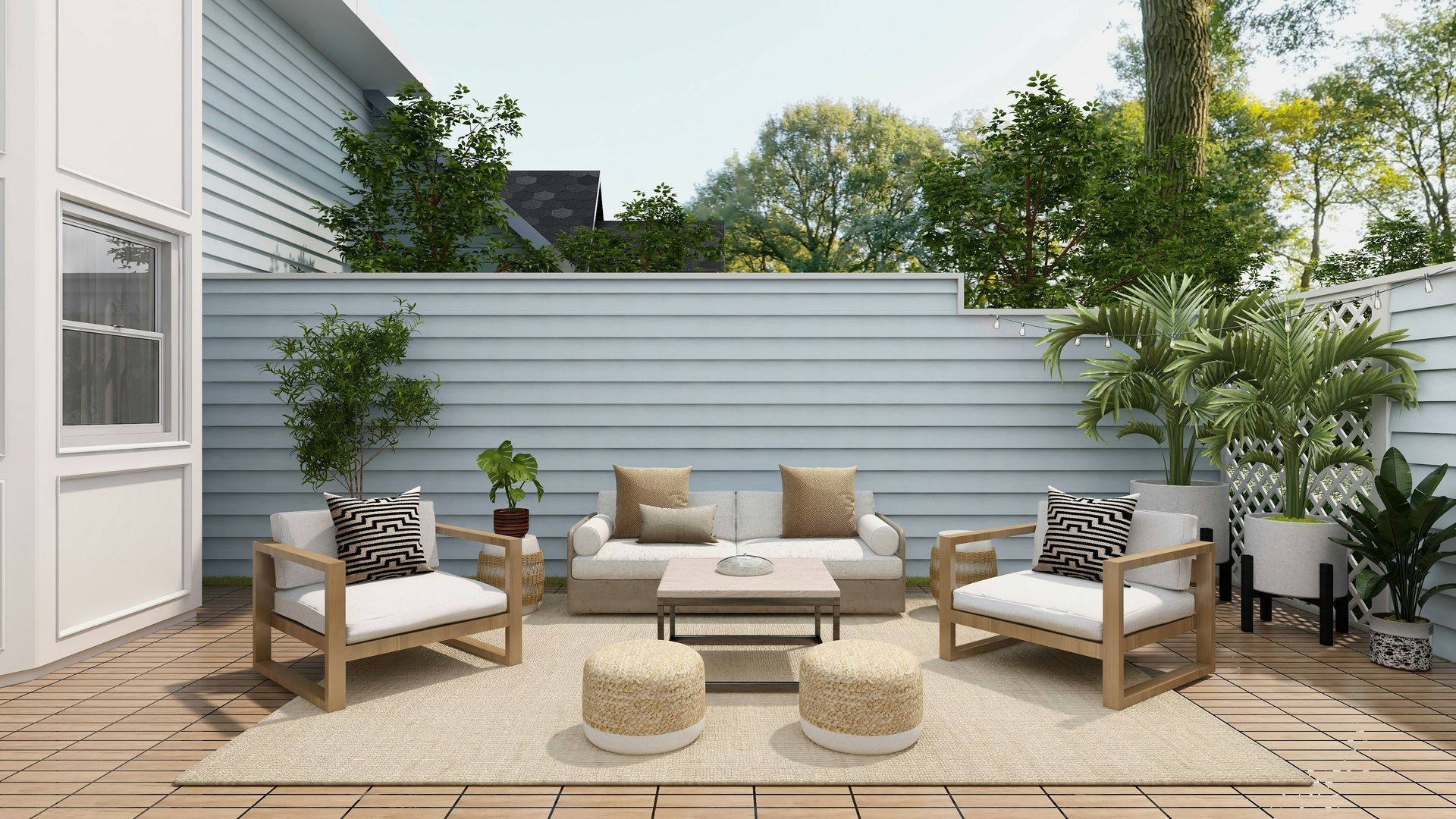 Patio seating area with white benches, beige cushions, potted plants, and a low coffee table against a gray fence