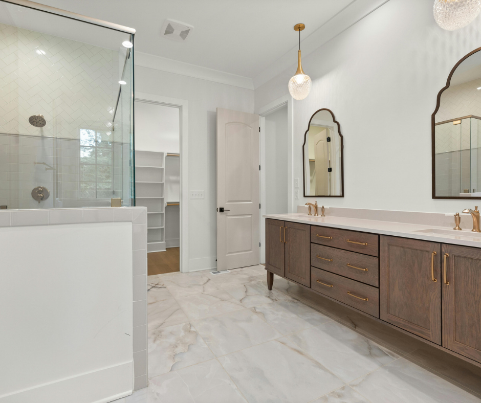 Modern bathroom with glass shower, dark wood double vanity, and marble tile flooring