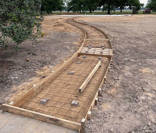 Curving wooden walkway foundation with wire mesh in a dry park area under construction