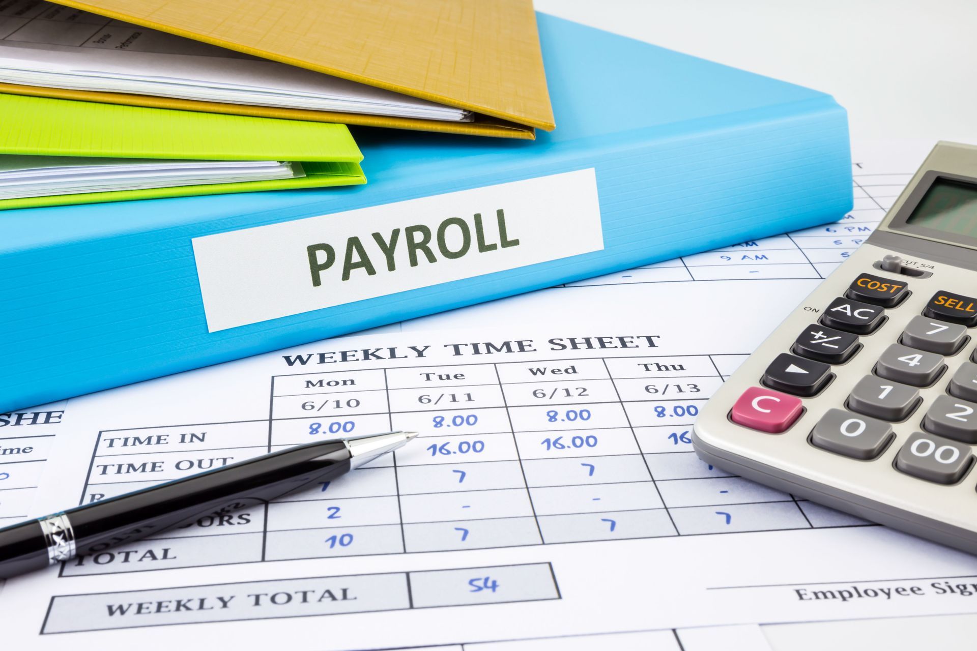 Payroll documents with calculator and pen on a desk, with folders in the background