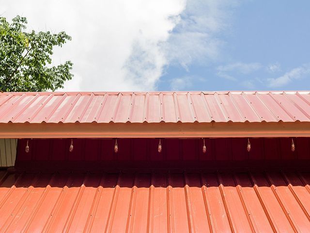 A red metal roof with a blue sky in the background.