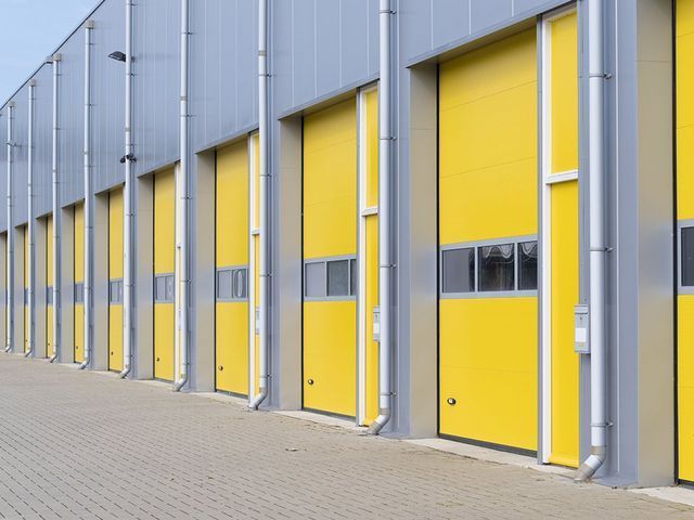 A row of yellow garage doors on a building