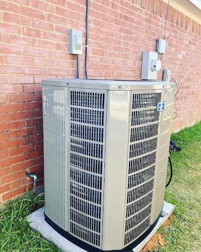 Outdoor air conditioner unit beside a brick house wall with electrical meters and conduit above it