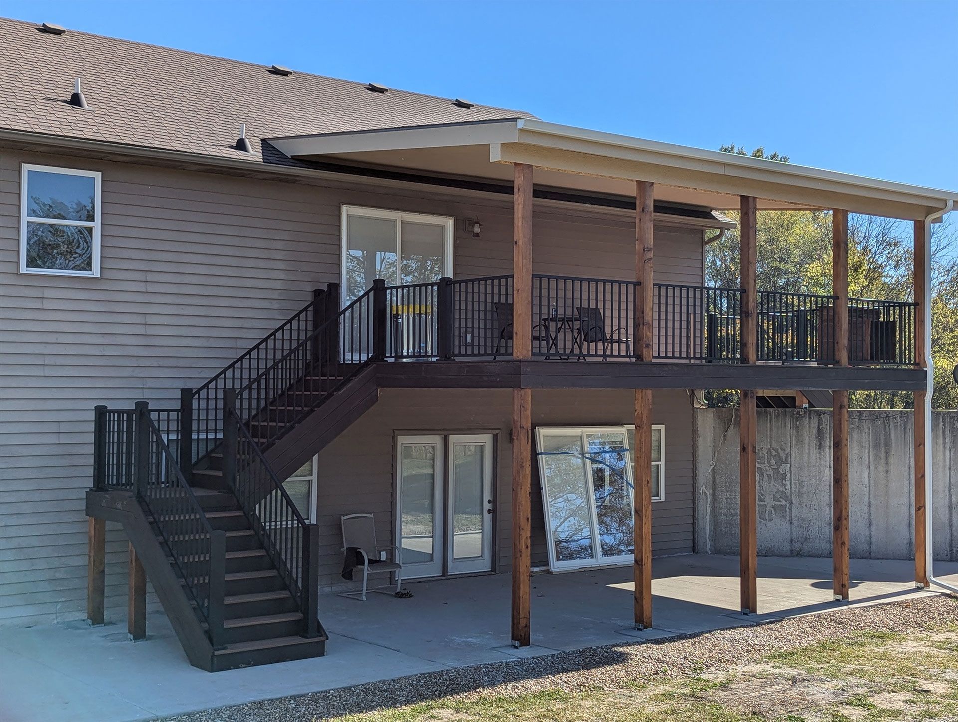 The back of a house with a large deck and stairs leading up to it