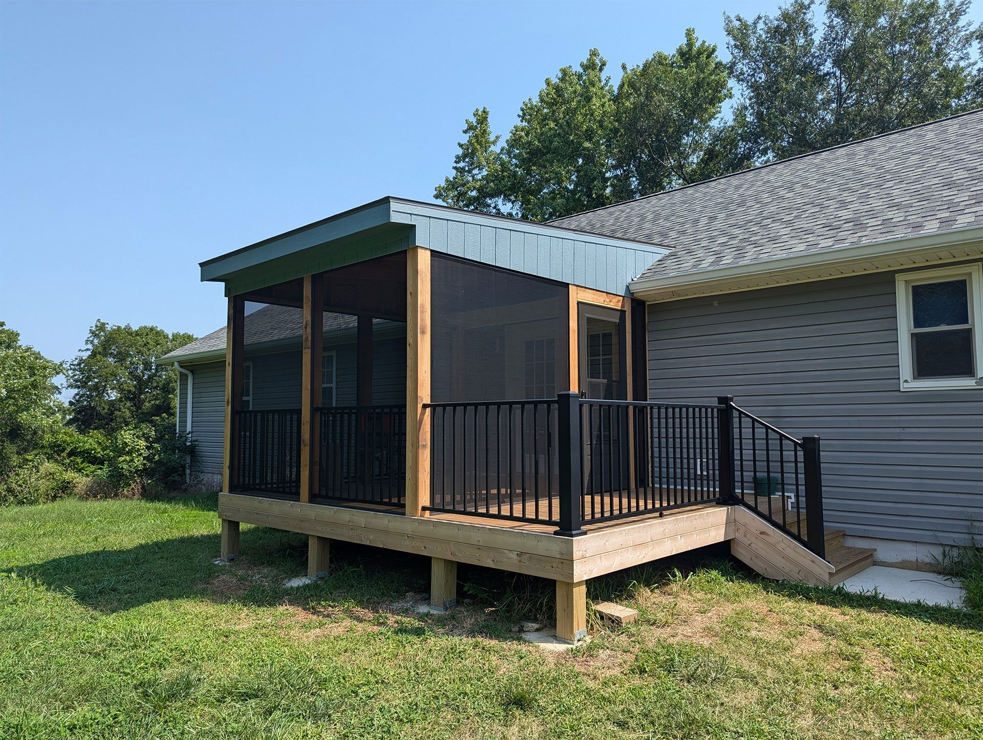 A screened in porch next to  a deck