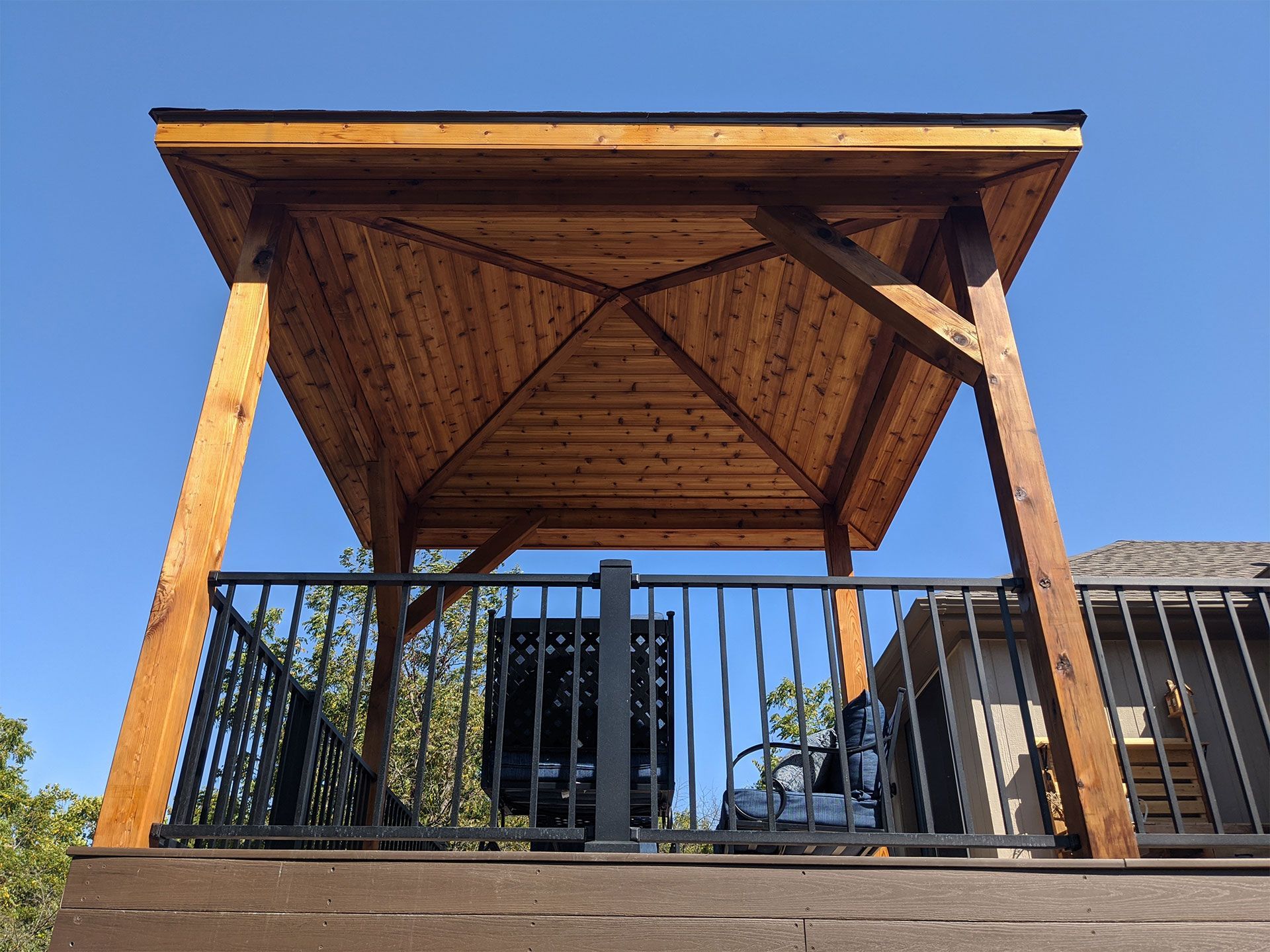 A wooden gazebo is sitting on top of a wooden deck