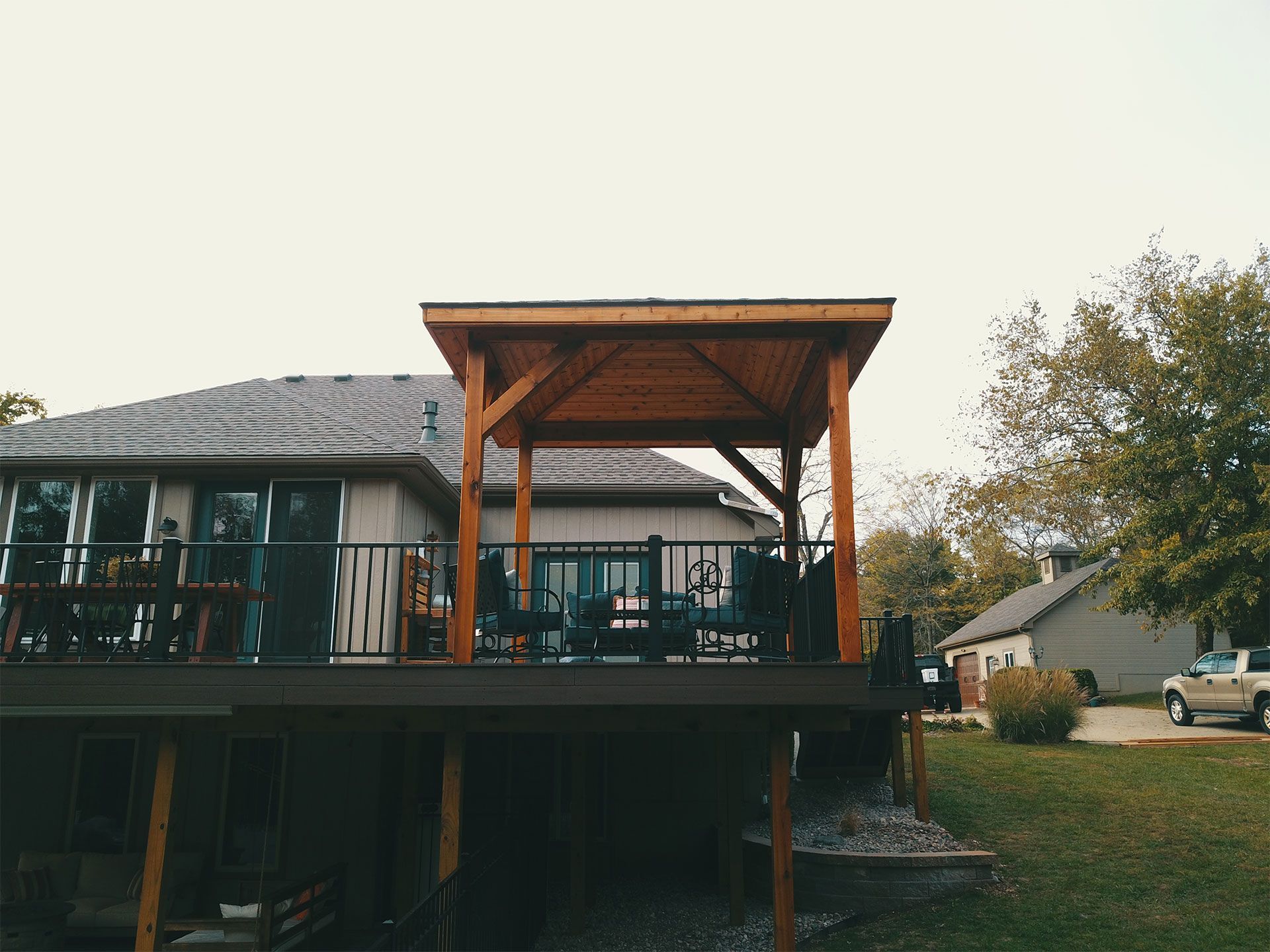 A house with a large deck and a gazebo in front of it