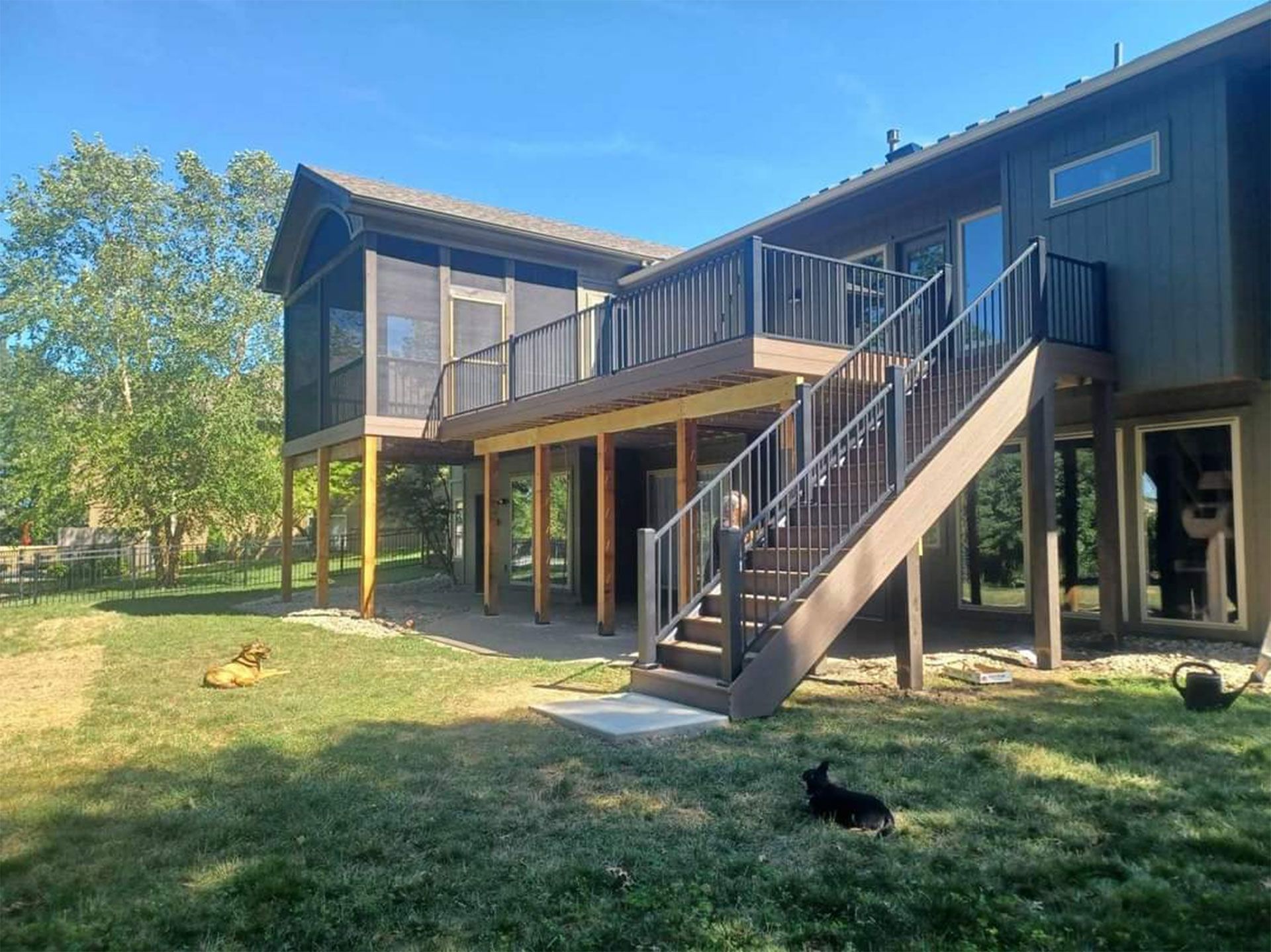A large house with a large deck and stairs in the backyard
