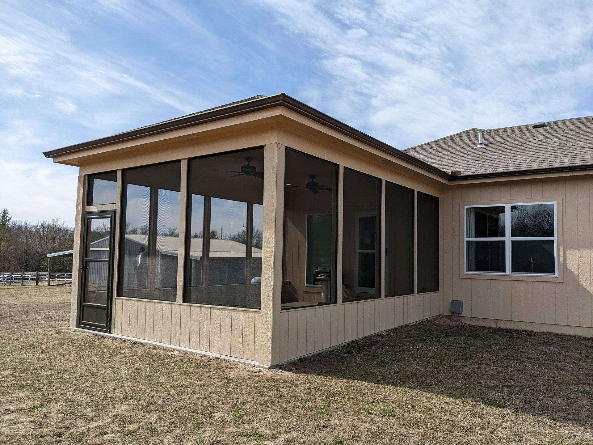 A screened in porch on the side of a house
