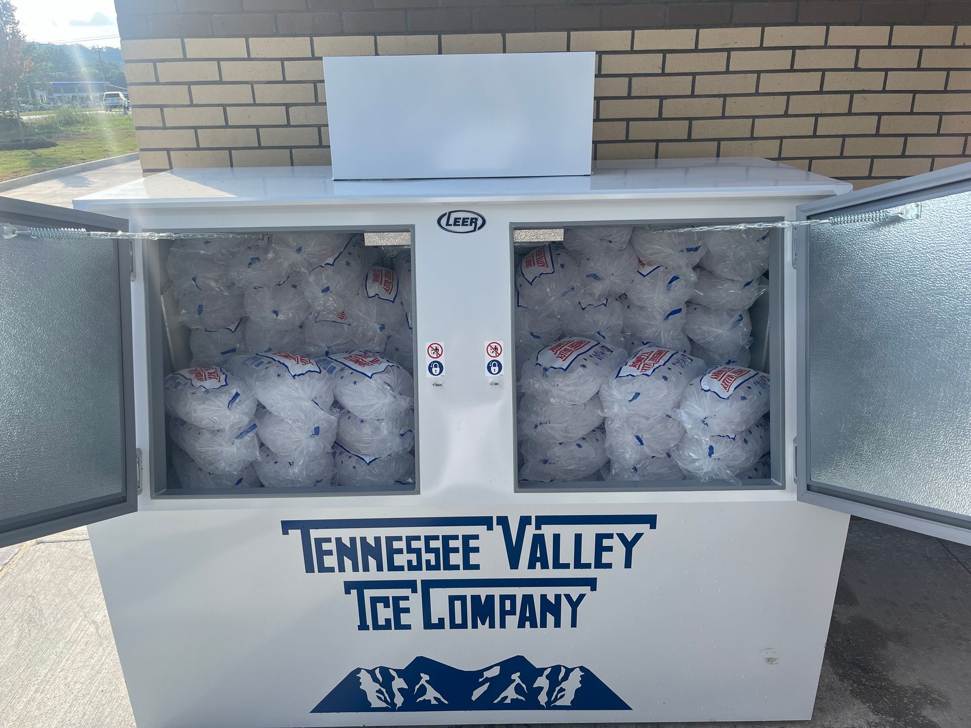 White ice cooler from Tennessee Valley Ice Company, filled with bagged ice.